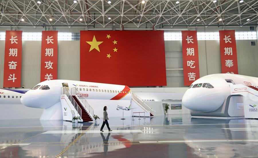Zhao Chunling passa davanti ai modelli degli aerei C919 e C929 in un istituto di ricerca della Commercial Aircraft Corporation of China (COMAC) a Shanghai, nella Cina orientale. (5 marzo 2025 - Xinhua/Liu Ying)