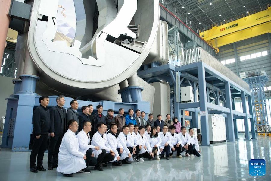 Ricercatori ed esperti posano per le foto vicino alla componente della camera a vuoto e al sistema di installazione generale, uno dei sottosistemi chiave del Comprehensive Research Facility for Fusion Technology (CRAFT), a Hefei, capoluogo della provincia orientale cinese dell'Anhui. (9 marzo 2025 - Xinhua/Zhang Duan)
