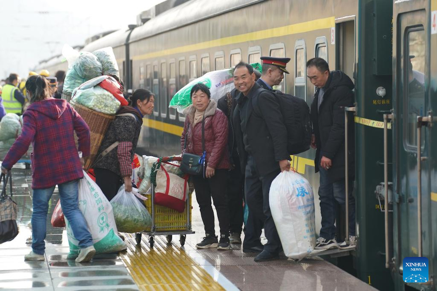 Passeggeri salgono e scendono dal treno n. 6064 alla stazione Yangpingguan di Hanzhong, nella provincia nord-occidentale dello Shaanxi. (17 febbraio 2025 - Xinhua/Shao Rui)