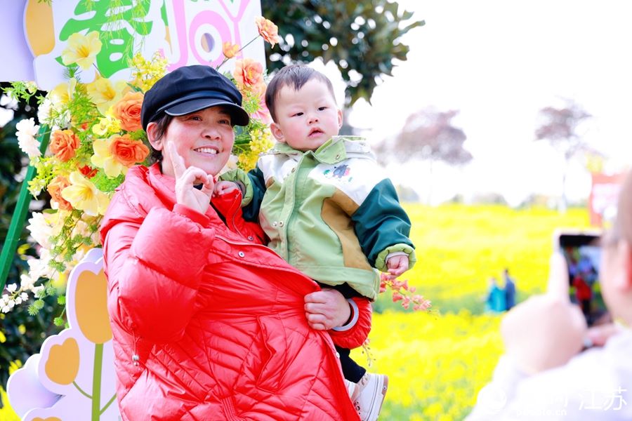 Turisti posano davanti al mare di fiori di colza. (16 marzo 2025 - Quotidiano del Popolo Online/Jiang Nan)