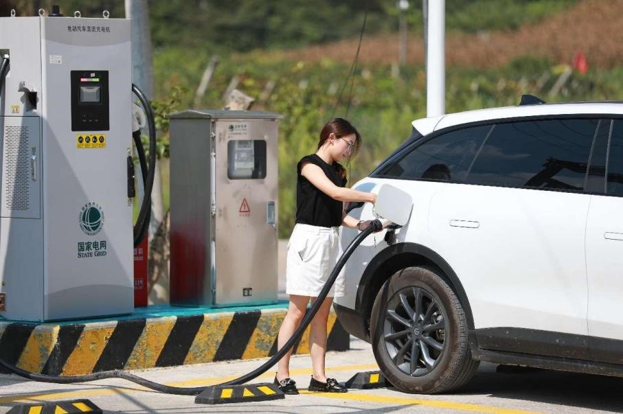 Una proprietaria di veicolo a nuova energia (NEV) carica la sua auto in una stazione locale nel villaggio di Xiamadong, nella contea di Badong, nella prefettura autonoma Enshi Tujia e Miao, nella provincia centrale cinese dello Hubei. (Quotidiano del Popolo/Jiao Guobin)