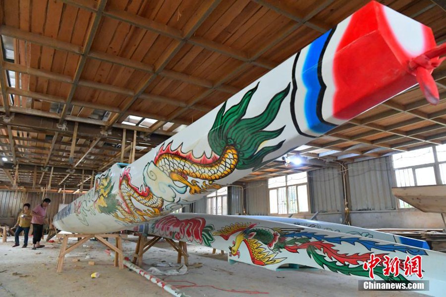 Artigiani lavorano alla realizzazione di barche drago ordinate per la Festa Duanwu nel villaggio di Fangzhuang. (25 maggio - China News Service/Zhang Bin)