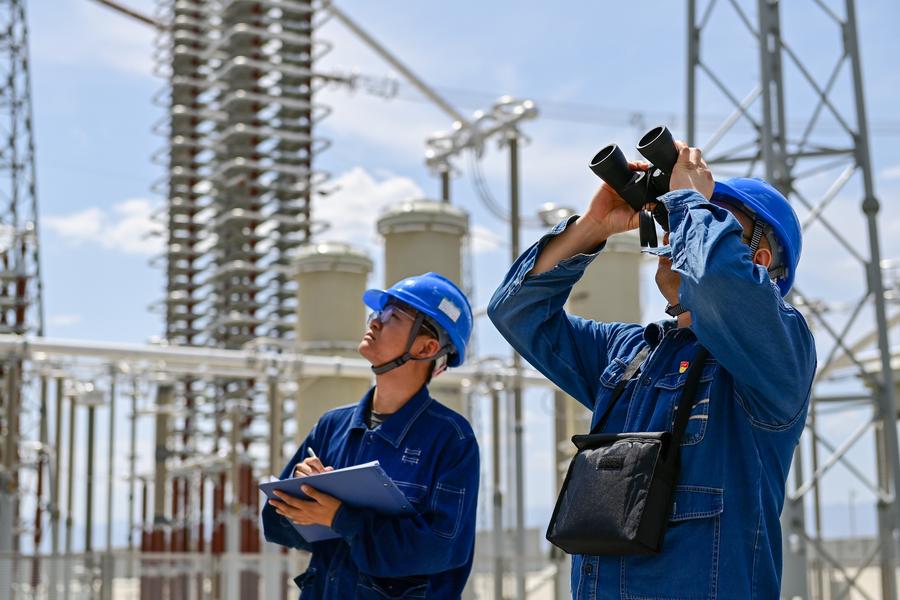 Membri del personale effettuano un'ispezione del progetto di trasmissione ad altissima tensione in corrente continua Hami-Chongqing nella stazione di conversione di Barkol a Hami, nella Regione Autonoma Uigura dello Xinjiang, nel nord-ovest della Cina. (10 giugno 2025 - Xinhua/Ding Lei)