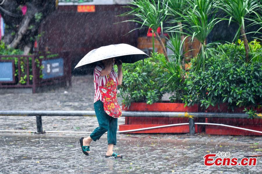 Donna cammina sotto la pioggia a Sanya, provincia di Hainan. (13 giugno 2025 - China News Service/Luo Yunfei)