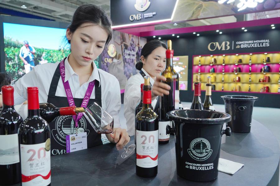 Volontari servono il vino prodotto ai piedi orientali del monte Helan durante il 32° Concours Mondial de Bruxelles (CMB) a Yinchuan, nella Regione Autonoma Hui del Ningxia, nella Cina nordoccidentale. (10 giugno 2025 - Xinhua/Du Juanjuan)