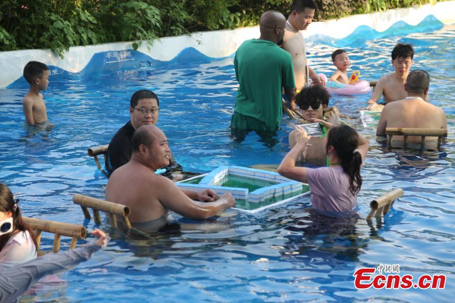 Abitanti di Chongqing giocano a Mahjong in acqua mentre continua l'allerta arancione per il caldo
