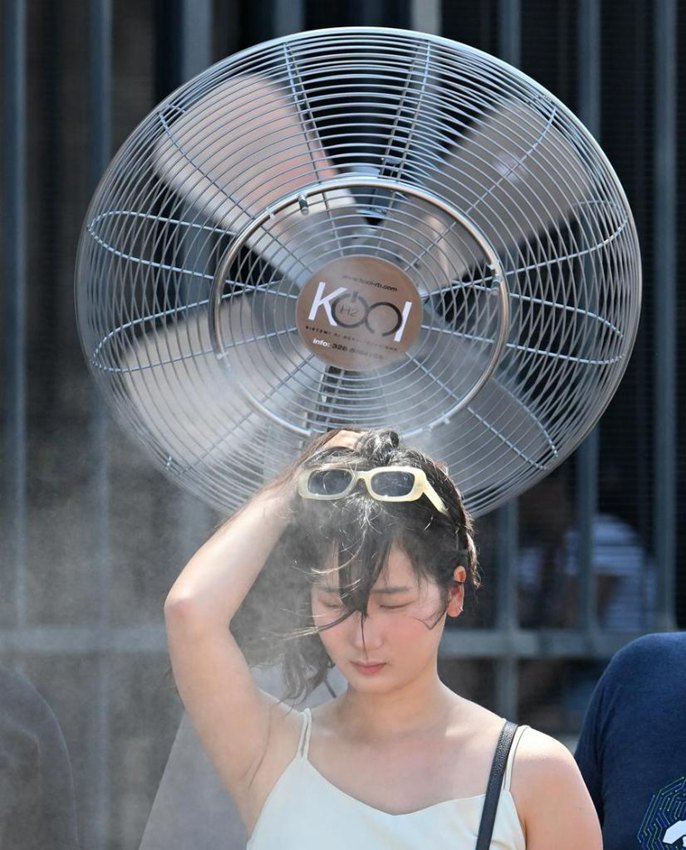 Turista si rinfresca sotto un ventilatore a Roma. (26 giugno 2025 - Xinhua/Alberto Lingria)