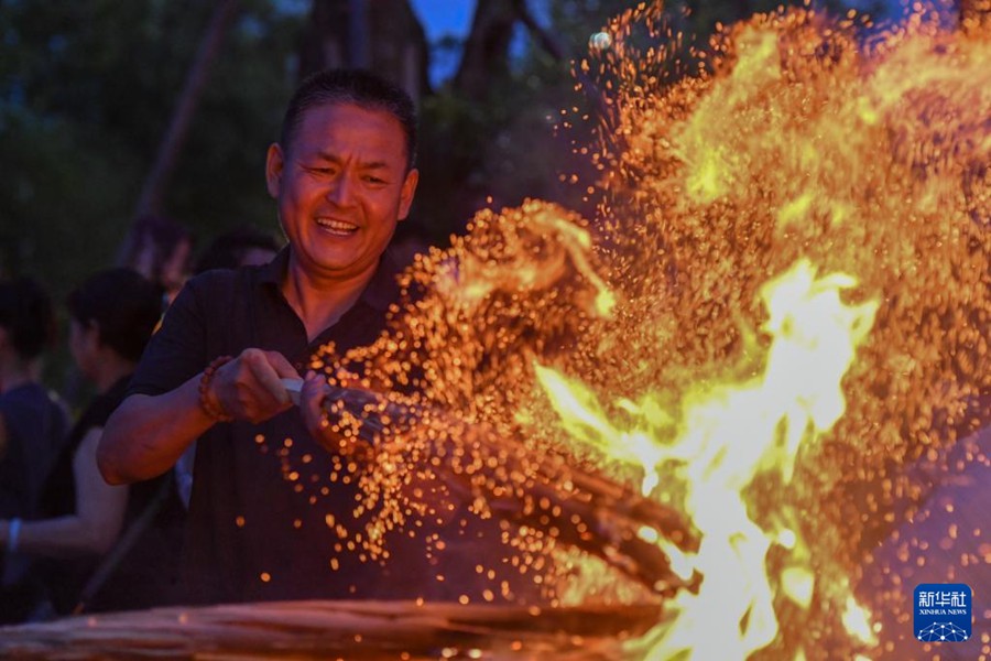 Un turista accende una torcia durante la Festa delle Torce nella Contea Autonoma Yi e Hui di Weishan, Prefettura Autonoma Bai di Dali, nella provincia dello Yunnan, Cina sud-occidentale. (19 luglio 2025 – Xinhua/Peng Yikai)