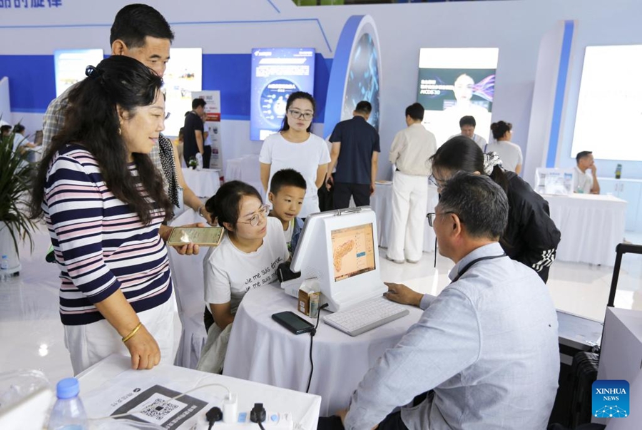 Visitatori sperimentano servizi sanitari di medicina tradizionale cinese con intelligenza artificiale durante la sesta Fiera dell'Industria della MTC (Gansu) nella contea di Longxi, città di Dingxi, provincia del Gansu, Cina nordoccidentale. (24 agosto 2025 – Xinhua/ Wang Kexian)