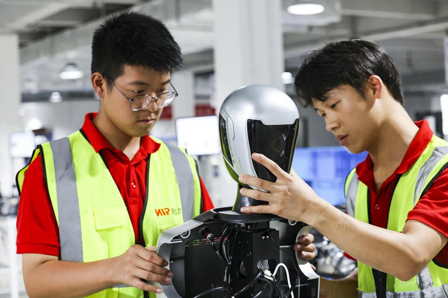 Tecnici della VMR eseguono il debug dei robot dotati del nuovo OmniHead sviluppato dall'azienda. (China Daily/Shi Zhaochang)