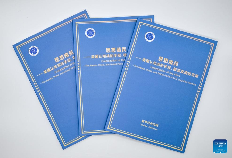 Copie del rapporto del think tank “Colonizzazione della mente: mezzi, radici e pericoli globali della guerra cognitiva statunitense”. (Xinhua/Chen Yehua)