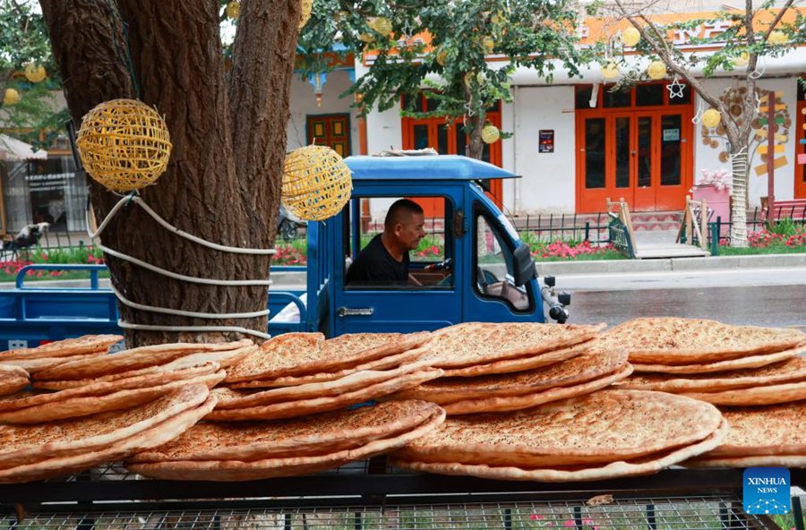 Bancarella che vende naan lungo una strada nella città di Kuqa, nella Regione Autonoma Uigura dello Xinjiang, nella Cina nord-occidentale. (21 luglio 2025 - Xinhua/Wang Jingqiang)
