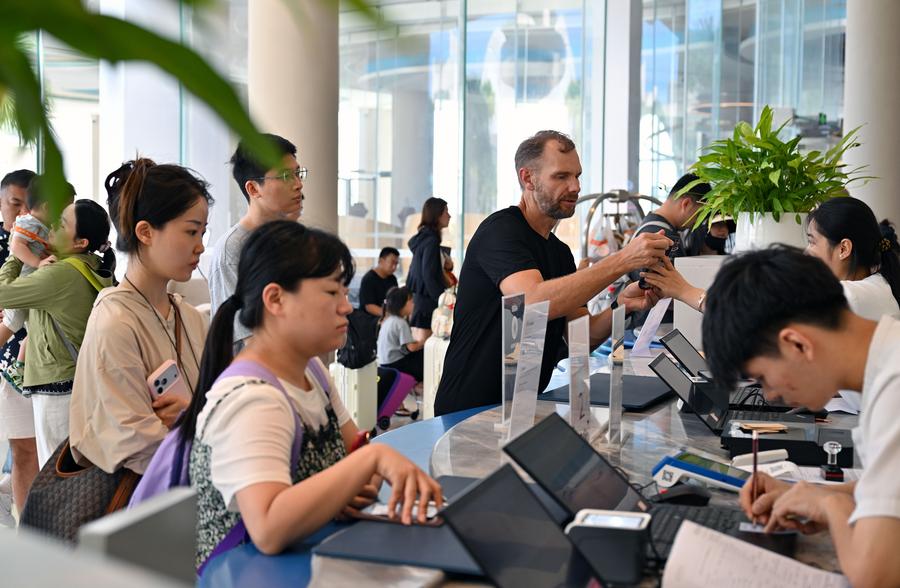 Turisti effettuano check-in e check-out in un hotel nella contea autonoma Li di Lingshui, nella provincia meridionale cinese di Hainan. (18 ottobre 2025 - Xinhua/Guo Cheng)