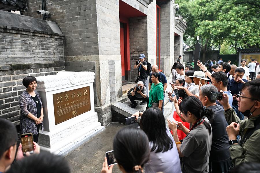 Persone scattano foto del cartello Patrimonio dell'umanità UNESCO appena inaugurato sulla Torre della Campana, un antico punto di riferimento sull'Asse Centrale di Beijing, capitale della Cina. (27 luglio 2025 - Xinhua/Chen Zhonghao)
