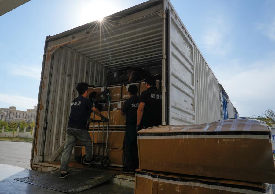 Addetti scaricano merci da esportare da un camion presso il parco industriale per l'e-commerce transfrontaliero di Alashankou, nella Regione Autonoma Uigura dello Xinjiang, nella Cina nord-occidentale. (11 settembre 2025 - Xinhua/Zhang Haobo)