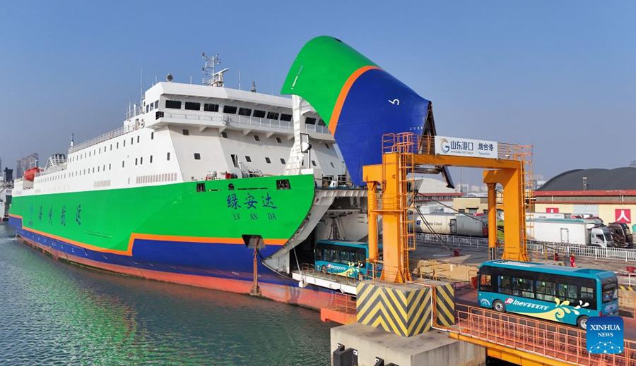 Autobus elettrici si imbarcano su una nave dedicata al trasporto di veicoli a nuova energia nel porto di Yantai, Shandong