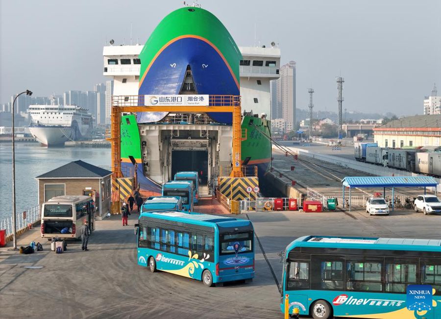 Autobus elettrici si imbarcano su una nave dedicata al trasporto di veicoli a nuova energia nel porto di Yantai, Shandong