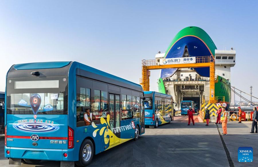 Autobus elettrici si imbarcano su una nave dedicata al trasporto di veicoli a nuova energia nel porto di Yantai, Shandong