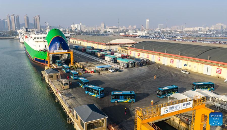 Autobus elettrici si imbarcano su una nave dedicata al trasporto di veicoli a nuova energia nel porto di Yantai, Shandong