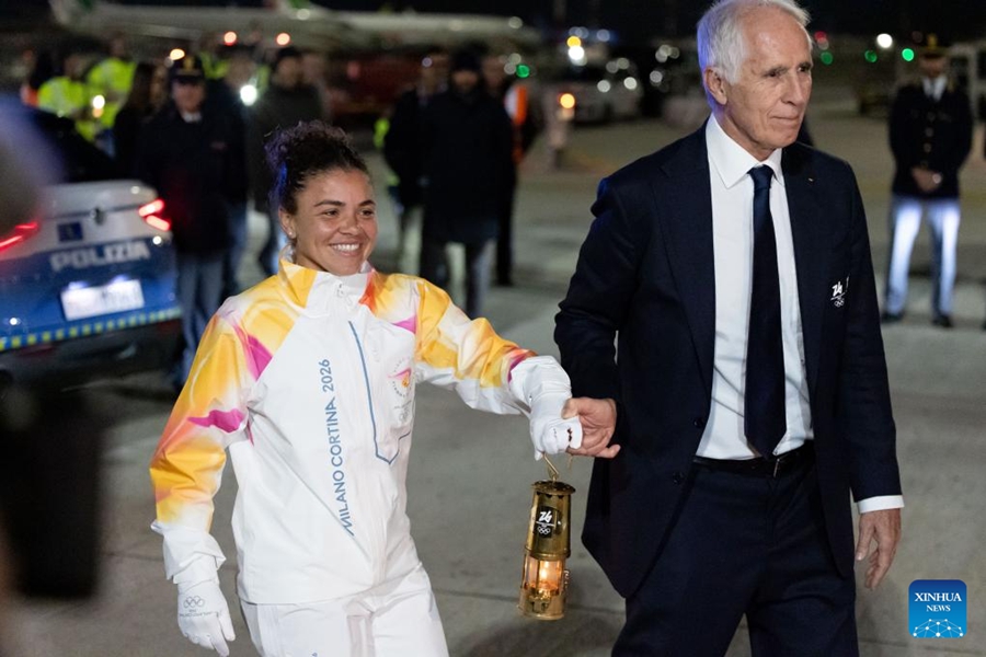 La tennista e campionessa olimpica italiana Jasmine Paolini (sinistra) e Giovanni Malago, presidente del comitato organizzatore Milano-Cortina, portano la lanterna contenente la fiamma delle Olimpiadi Invernali Milano-Cortina 2026 all'Aeroporto Fiumicino di Roma, Italia. (4 dicembre 2025 - Xinhua/Li Jing)