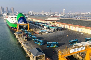 Autobus elettrici si imbarcano su una nave dedicata al trasporto di veicoli a nuova energia nel porto di Yantai, Shandong