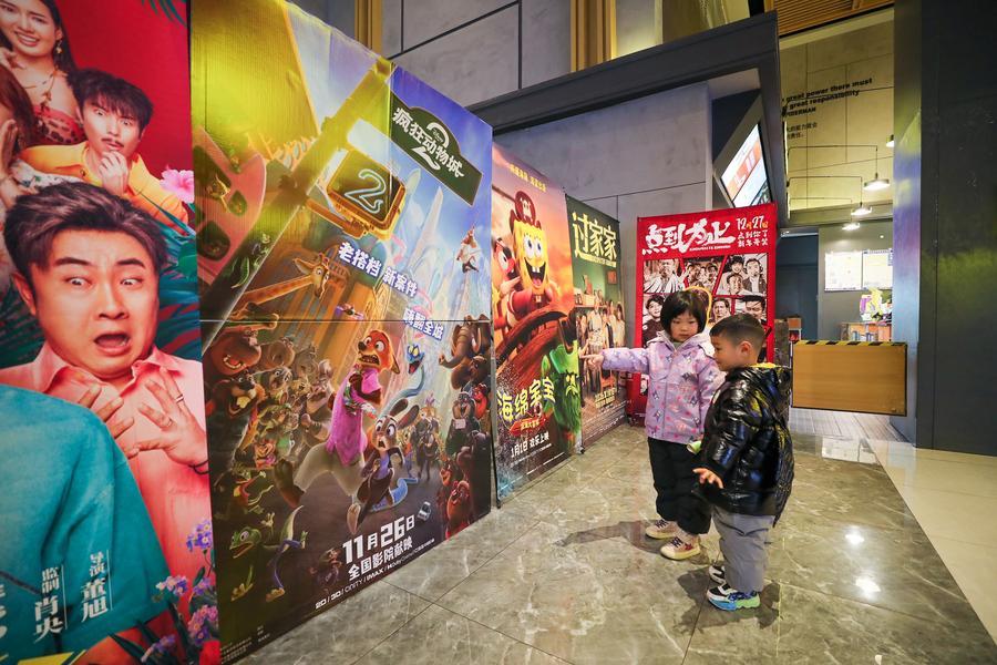 Bambini osservano un poster del film Zootropolis 2 in un cinema a Hai'an, nella provincia del Jiangsu, Cina orientale. (2 gennaio 2026 - Xinhua/Gu Binbin)