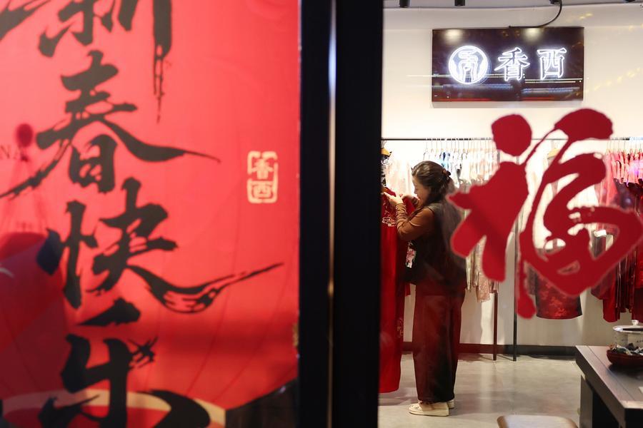 Una negoziante sistema dei Qipao, abiti tradizionali cinesi da donna, in un negozio nel distretto di Qilihe a Lanzhou, nella provincia del Gansu, Cina nordoccidentale. (6 gennaio 2026 - Xinhua/Chen Bin)