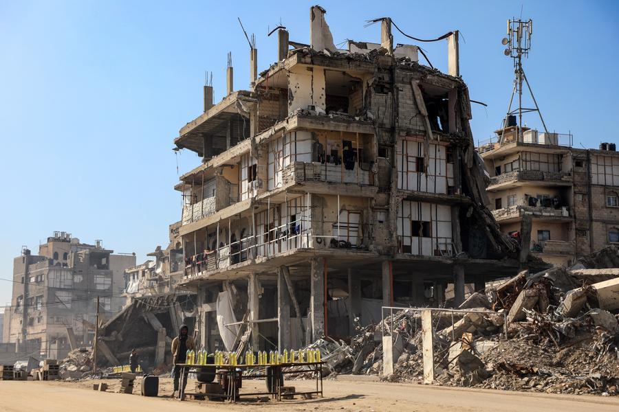 Venditori ambulanti nei pressi di edifici danneggiati a Gaza City. (15 gennaio 2026 - Rizek Abdeljawad/Xinhua)