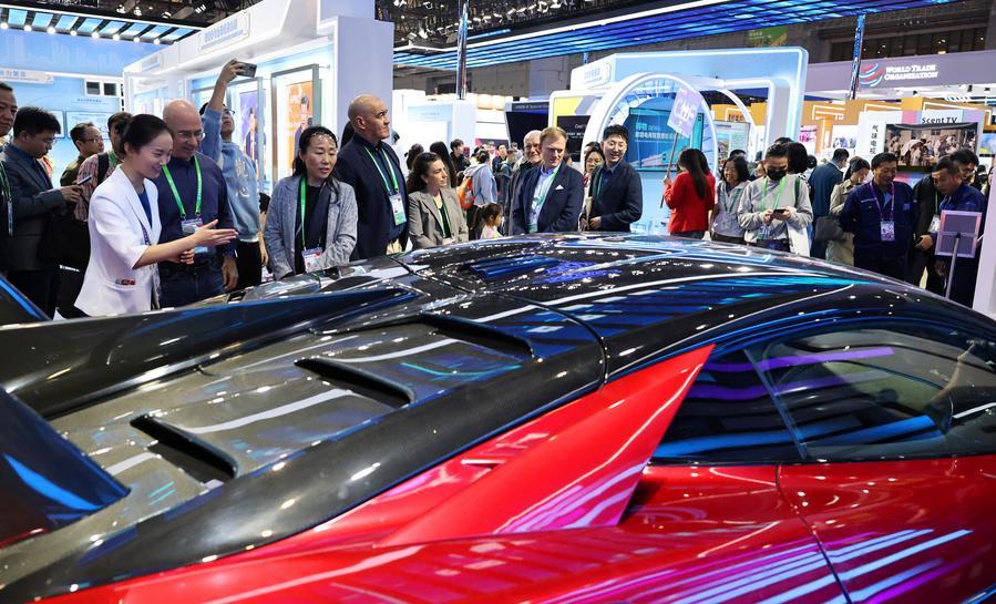 Visitatori osservano un veicolo a energia nuova (NEV) della BYD, azienda leader cinese nella produzione di veicoli elettrici, presso il padiglione cinese dell'ottava edizione della China International Import Expo (CIIE) a Shanghai, nella Cina orientale. (8 novembre 2025 - Xinhua/Fang Zhe)