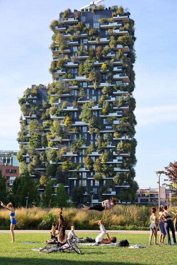 Persone praticano yoga di fronte al "Bosco Verticale", un edificio simbolo di Milano. (17 settembre 2025 - Xinhua/Li Jing)