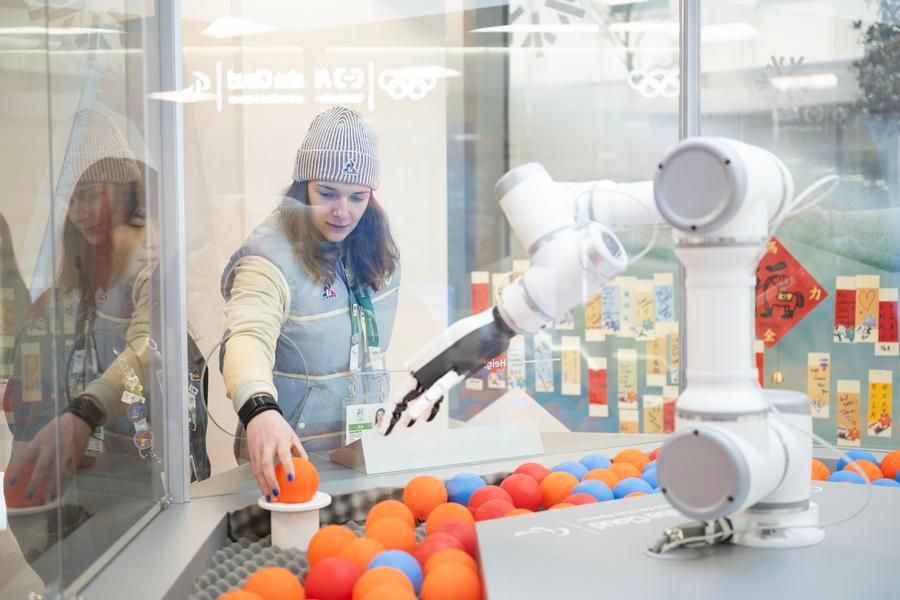 La giocatrice francese di hockey su ghiaccio Anae Simon davanti alla stazione intelligente per lo scambio di spille di Alibaba al Villaggio Olimpico dei Giochi Olimpici Invernali di Milano-Cortina 2026, a Milano. (3 febbraio 2026 - Xinhua/Zhang Haofu)