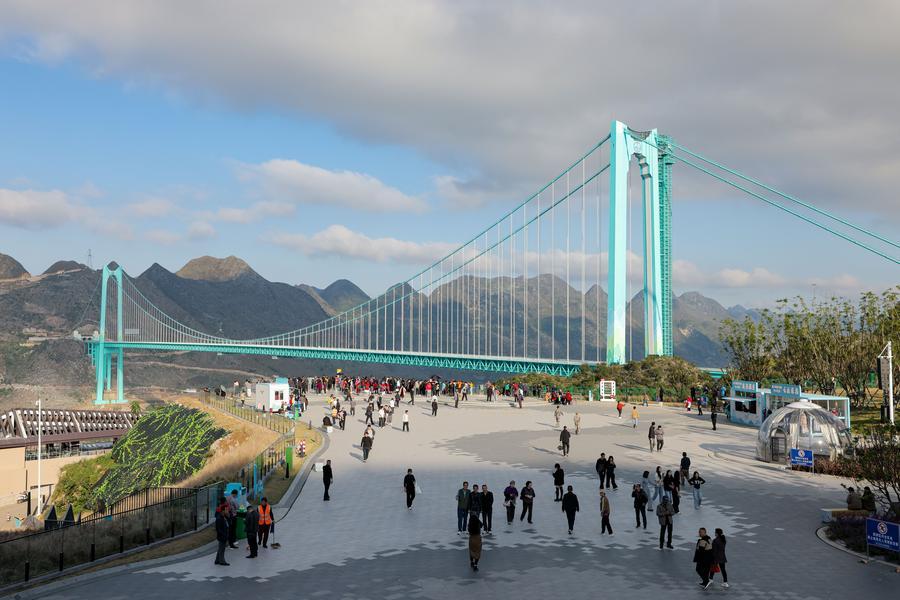 Turisti ammirano il ponte del Grand Canyon di Huajiang nella vicina area di servizio di Yundu, nella provincia del Guizhou. (6 novembre 2025 - Xinhua/Ou Dongqu)