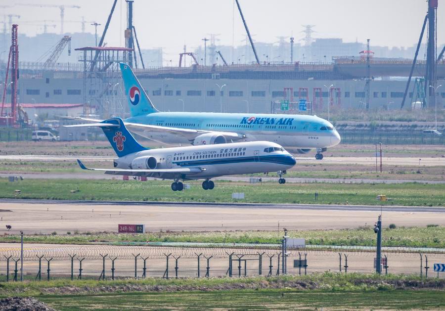 Un aereo di linea C909 (in primo piano) della China Southern Airlines atterra all'Aeroporto Internazionale di Shanghai Pudong, a Shanghai, Cina orientale. (15 aprile 2025 - Xinhua/Xu Bingnan)