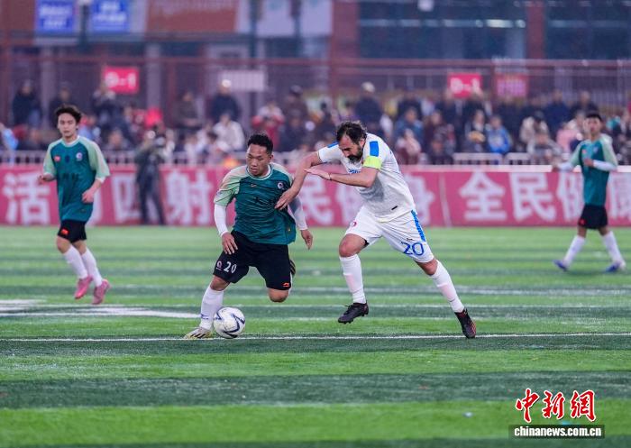 Giocatori della squadra dell'Ordine degli Ingegneri della Provincia di Roma e della squadra del villaggio di Dali Dong si contendono il pallone, nella contea di Rongjiang. (Wei Guijin)