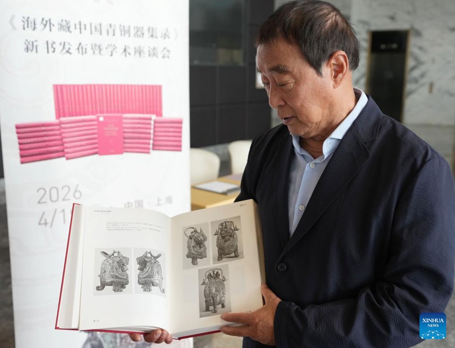 Il professor Zhu Fenghan, curatore capo di un compendio in sessanta volumi che documenta oltre 23.000 antichi manufatti cinesi in bronzo dispersi all'estero, illustra i contenuti di uno dei libri durante una conferenza stampa per la presentazione dell'opera a Shanghai, nella Cina orientale. (19 aprile 2026 - Xinhua/Liu Ying)