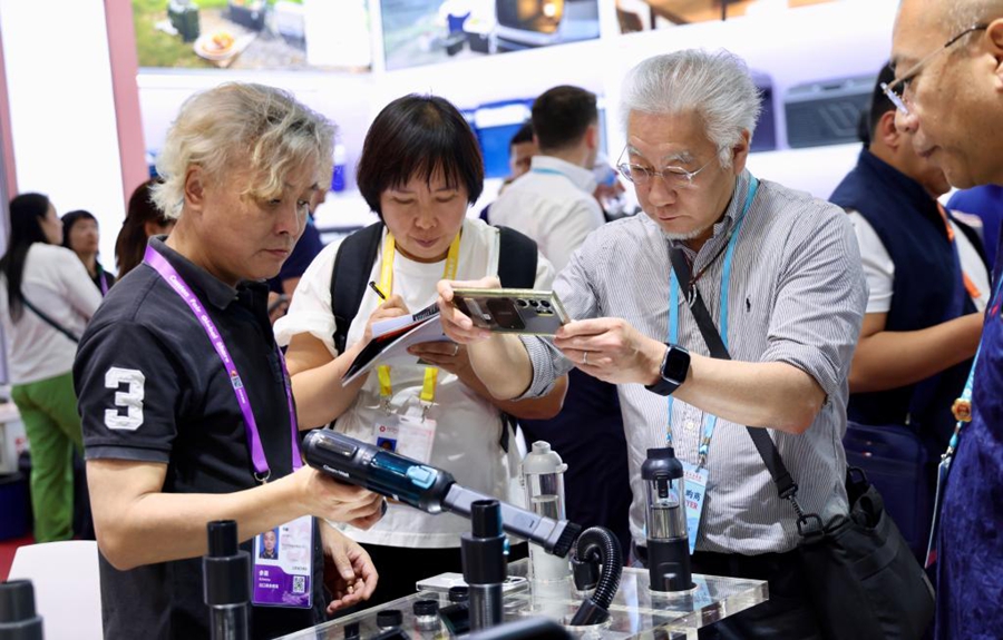 Acquirenti esteri osservano un aspirapolvere durante la 139ª edizione della Fiera di Canton a Guangzhou, nella provincia del Guangdong (Cina meridionale). (15 aprile 2026 - Xinhua/Lu Hanxin)