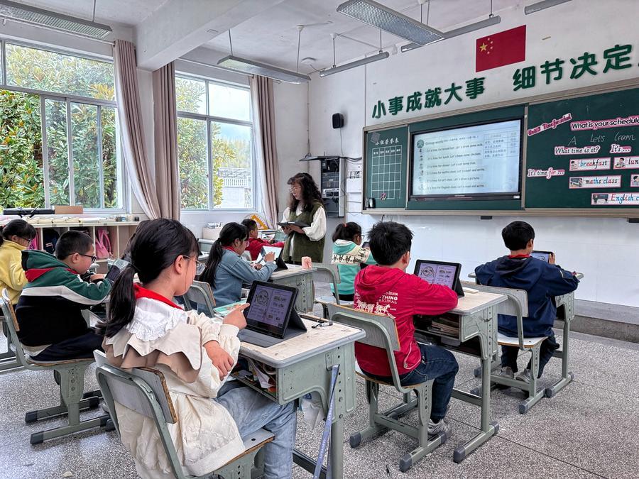 Studenti interagiscono con l'assistente basato sull'IA "Qian Xiaowa" durante una lezione di cinese presso la Scuola Centrale del borgo di Qixi, nella contea di Kaihua, provincia del Zhejiang, Cina orientale. (17 aprile 2026 - Xinhua)