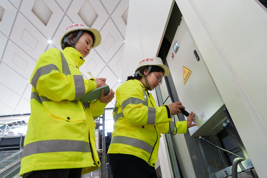 Il personale esegue l'ispezione finale di collaudo dei quadri di distribuzione a bassa tensione all'interno dell'edificio della stazione. (Ma Yizhe/ Quotidiano del Popolo Online)