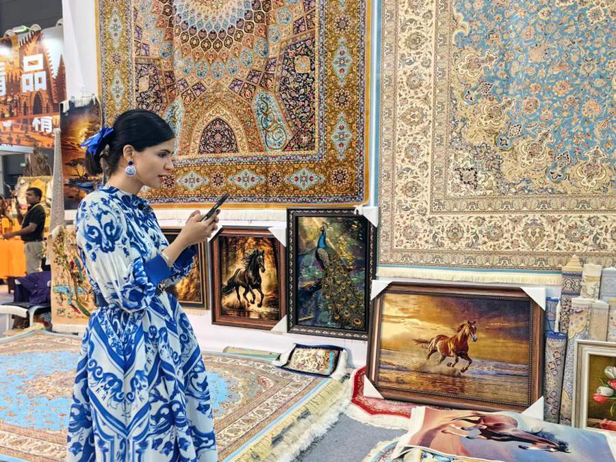 Un membro dello staff presenta dei prodotti in diretta streaming presso lo stand dell'Iran, durante la 10ª Esposizione Internazionale della Via della Seta a Xi'an, nella provincia dello Shaanxi, Cina nord-occidentale. (21 maggio 2026 - Xinhua/Zhang Sijie)