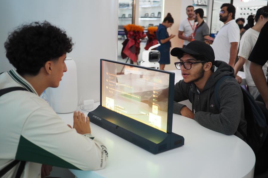 Commercianti stranieri provano un dispositivo interattivo di traduzione basato sull'intelligenza artificiale presso il Global Digital Trade Center di Yiwu, nella provincia del Zhejiang, Cina orientale. (14 ottobre 2025 - Xinhua/Liu Ziyi)