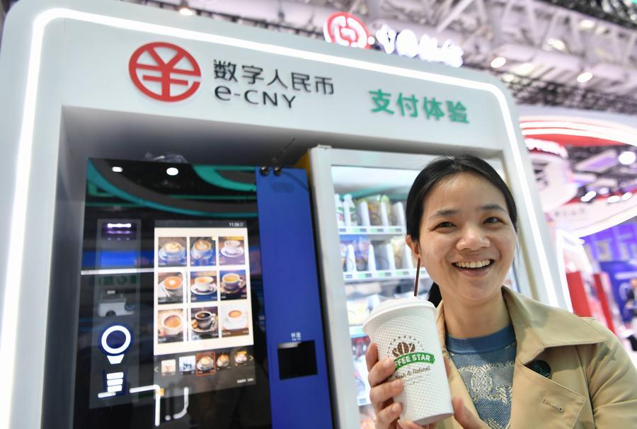 Visitatrice mostra una tazza di caffè acquistata utilizzando lo yuan digitale cinese (e-CNY) durante una mostra del 6° Digital China Summit a Fuzhou, nella provincia del Fujian, Cina orientale. (26 aprile 2023 - Xinhua/Wei Peiquan)