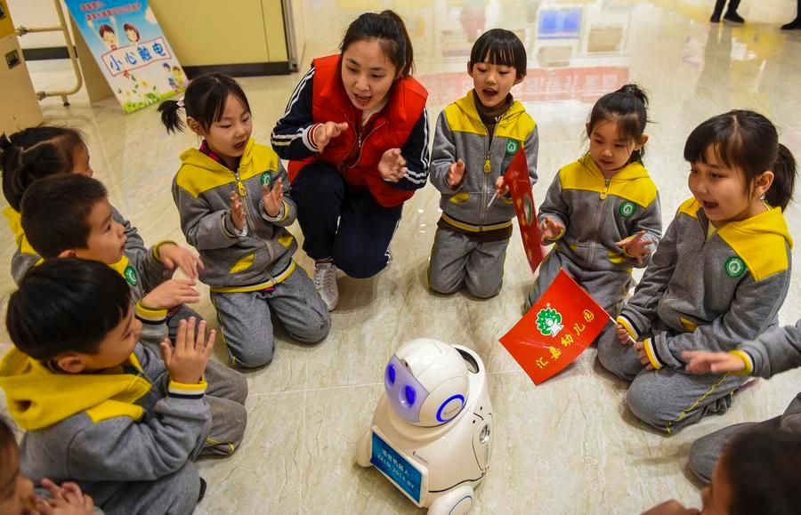Bambini di una scuola dell'infanzia interagiscono con un robot presso un museo mobile della scienza e della tecnologia a Shenzhou, nella provincia dello Hebei, nel nord della Cina. (10 novembre 2018 - Xinhua/Li Xiaoguo)