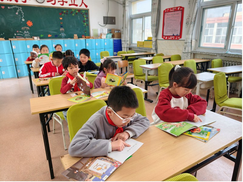 Studenti di seconda elementare leggono libri illustrati in inglese presso la Scuola Primaria Centrale del comune di Dongshaoqu, nel distretto Miyun di Beijing. (Quotidiano del Popolo Online/Chang Sha)