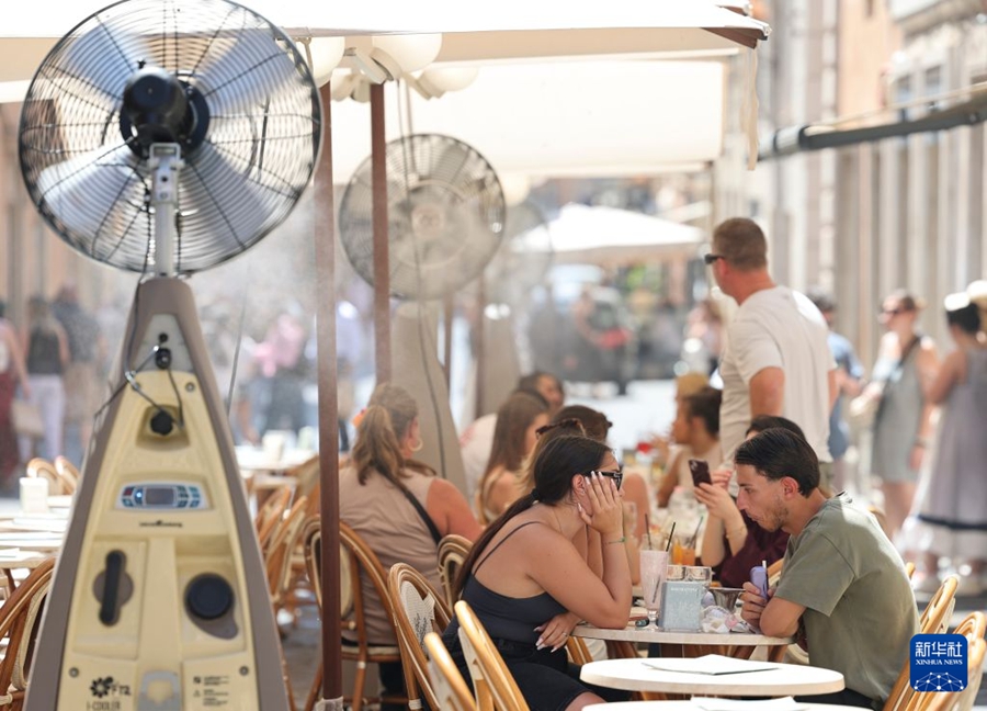 Persone cenano all'aperto in un ristorante di Roma, sotto i ventilatori. (21 giugno 2026 - Xinhua/Li Jing)