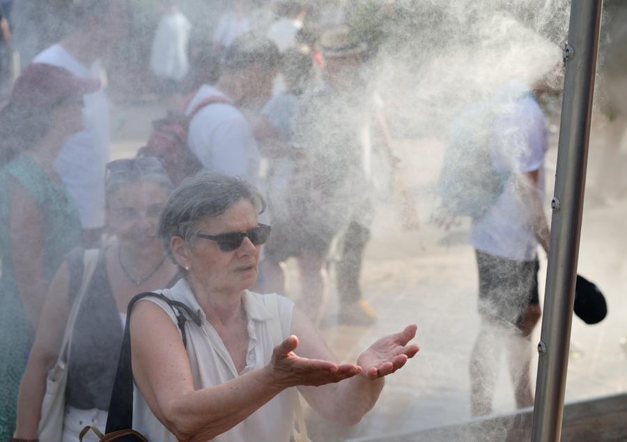 Persone si rinfrescano davanti a una postazione di nebulizzazione al Roland Garros durante un'ondata di caldo a Parigi, Francia. (28 maggio 2026 - Xinhua/Wu Huiwo)