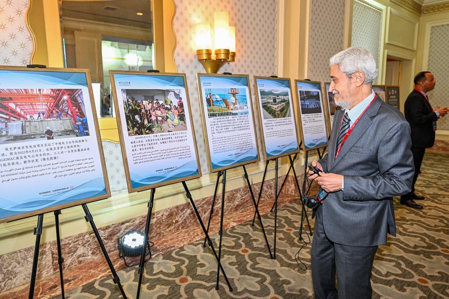 Partecipante alla Global South Media and Think Tank Forum Chinese-Arab Partnership Conference, osserva le opere esposte in una mostra fotografica e artistica dedicata alla cooperazione tra Cina e mondo arabo, al Cairo, Egitto. (13 maggio 2026 - Xinhua/Xin Mengchen)