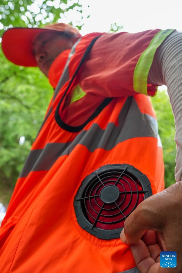 Operatori ecologici dotati di gilet refrigeranti per affrontare il caldo estivo a Nanjing