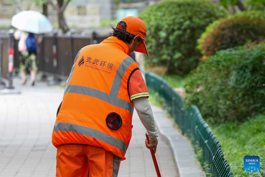 Operatori ecologici dotati di gilet refrigeranti per affrontare il caldo estivo a Nanjing