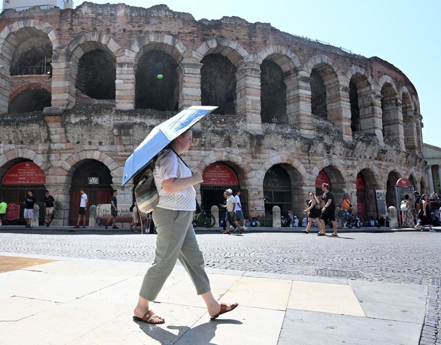 Una turista si ripara dal sole con un ombrello vicino all'Arena di Verona. (2 agosto 2026 - Alberto Lingria/Xinhua)