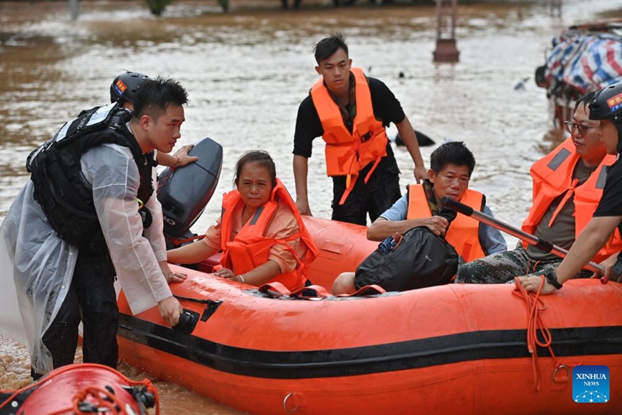 Soccorritori evacuano i residenti rimasti bloccati a seguito delle forti piogge nel Guangxi